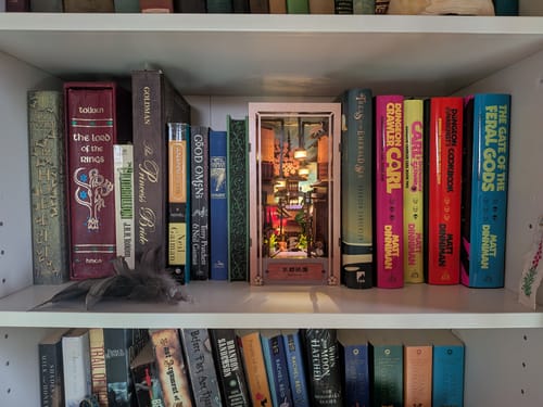 Customer's Kyoto Gion Book Nook Kit displayed on a white bookshelf between various books.