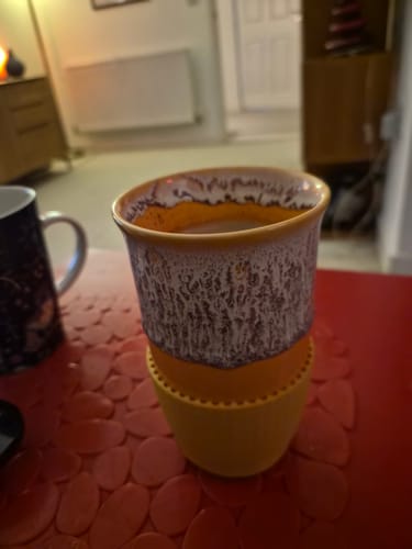 Customer's Grapefruit Cup in a two-tone yellow and white speckled stoneware design with a silicone band.