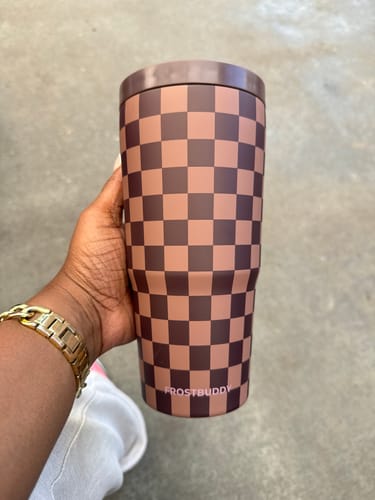 Customer's hand holding a brown and tan checkered To-Go Buddy espresso tumbler.