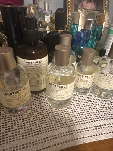 Customer's collection of Another 13 eau de parfum bottles displayed on a white lace surface.