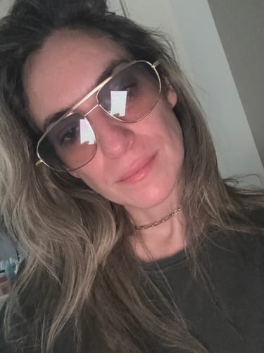 Cliente usando os Óculos de Sol Icon com armação de metal dourado e lentes com gradiente.