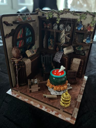 Customer's completed The Potion Workshop miniature kit, featuring a cauldron, witch's broom, and potion bottles.