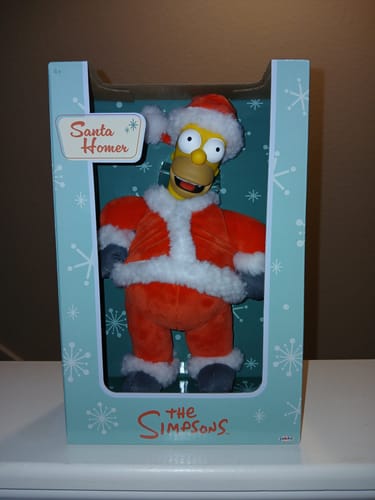 Customer's Santa Homer plush figure in its original illustrated box, featuring festive snowflake patterns.