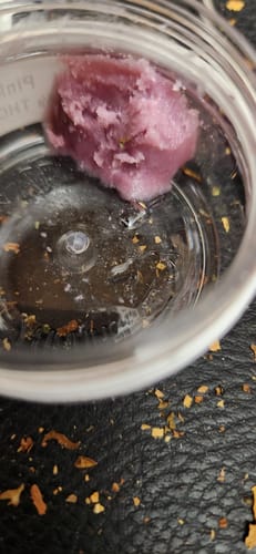 Customer's Pink Melt hash, a soft pink-purple resin in a clear plastic container