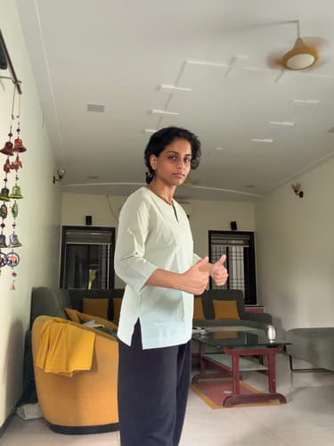 Customer's mint green short kurta being worn, with a person giving a thumbs up in a living room.