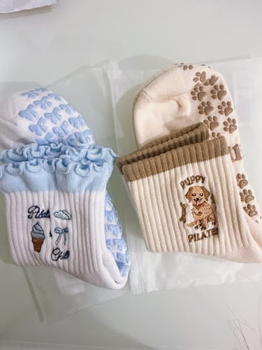 Customer's Puppy Pilates socks featuring cute embroidery on beige and white fabric with grippy soles.