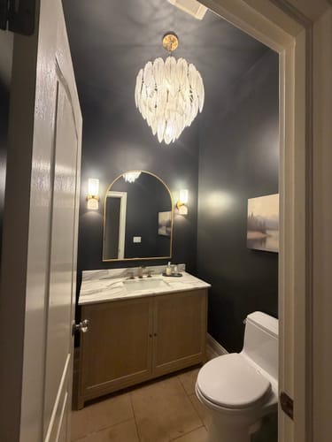 Customer's Smoky Peaks Canvas Art displayed on a dark bathroom wall, adding a moody aesthetic to the powder room.
