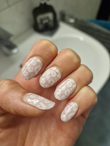 Customer's hand showing the Wild Blush UV Gel nails with a delicate leopard pattern and gold accent.