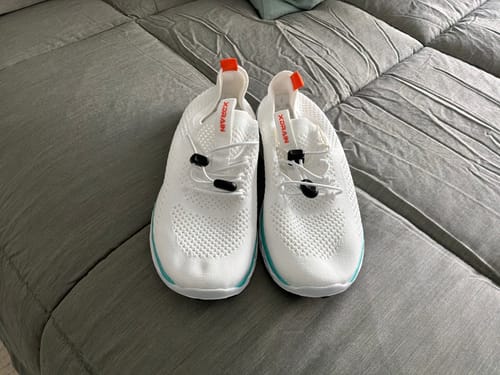 Customer's pair of Women's Xdrain Nova white water shoes with adjustable toggles, resting on a gray textured surface.