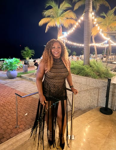 Customer's Crochet Fringe Halter Mini Dress in black, worn at a nighttime outdoor dinner.