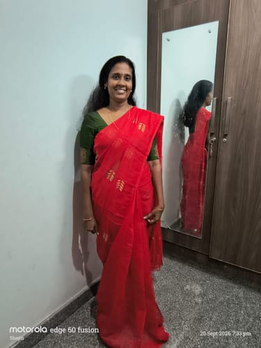 Customer's bright red Ful Bagan Dhakai Jamdani Saree with subtle weaving pattern, worn by a smiling person