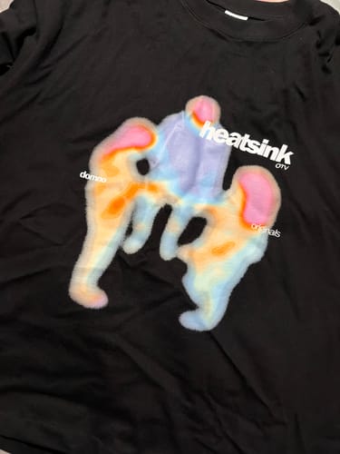 Reviewer's black Heatsink Tee showing the colorful graphic print of warm-toned thermal shapes on the chest