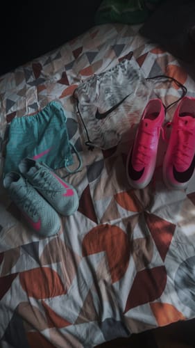 Customer's pair of Air Zoom Mercurial Vapor 16 football boots, one light blue and one pink, with matching gym bags.