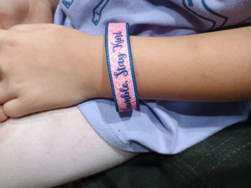 Customer's pink Stay Humble, Stay Kind bracelet worn on a child's wrist.