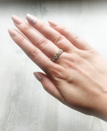 Customer's Sunset Ring on a hand, showing the gold-colored band with sparkling zirconia stones.