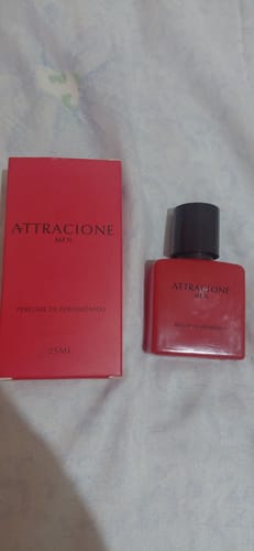 Customer's Attracione Men perfume box and red glass bottle, set on a textured white fabric.