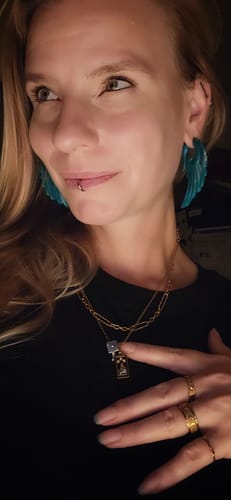 Customer's 7 for $85 Waterproof Jewelry Bundle featuring gold necklaces, rings, and teal wing earrings on a person.