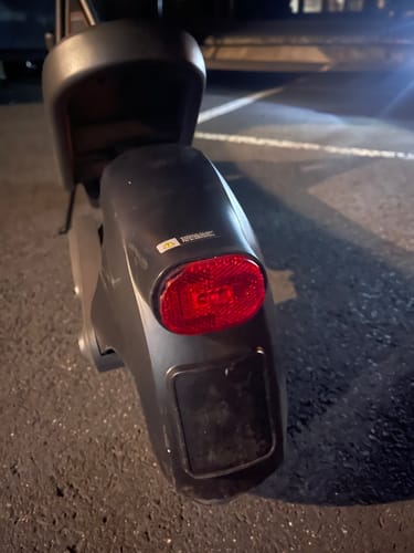 Reviewer's Xiaomi Electric Scooter 6 achterkant met rood achterlicht en spatbord op asfalt.