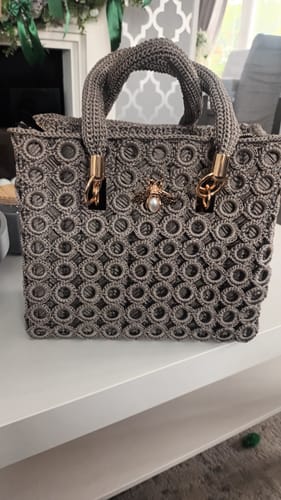 Customer's completed Garden Bee Crochet Bag Kit with a grey circular pattern and pearl bee charm.