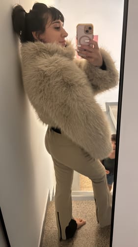 Customer's khaki slim-fit ski suit with faux fur jacket, worn in a mirror selfie.