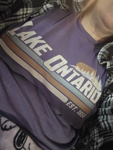 Customer's Lake Ontario Retro Stripe T-Shirt, a purple shirt featuring vintage graphics and a lighthouse print.