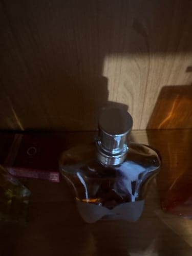 Customer's Jean Paul Gaultier Classique Eau de Toilette bottle on a wooden shelf in dim lighting.