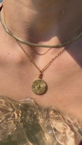 Reviewer's gold initialen halskette mit Anhänger, getragen im Wasser.