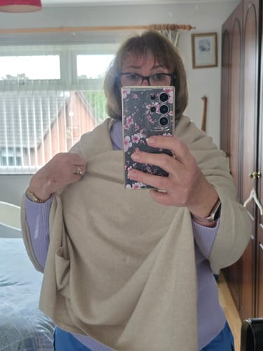 Reviewer wearing a sand beige, soft cashmere wrap in a mirror selfie.