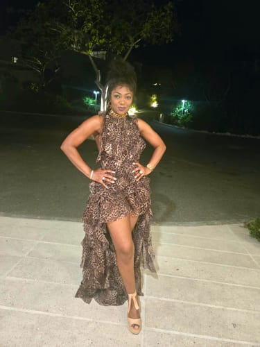 Reviewer's Chiffon Print Asymmetric Ruffle Dress in leopard print, standing outdoors at night.