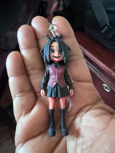 Customer's DoDoWish Custom 3D Keychain Figure, a mini doll with dark hair and a business suit held in a hand.
