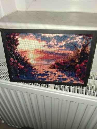 Kunden-Diamond-Painting Wunderschöner Sonnenuntergang in einem schwarzen Rahmen auf einem Heizkörper
