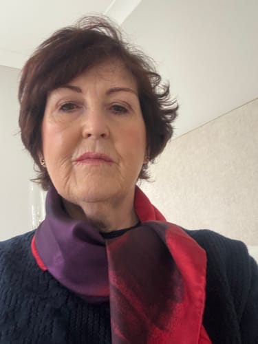 Customer's Gucci Red Typographic Silk Scarf with purple tones, worn around the neck.