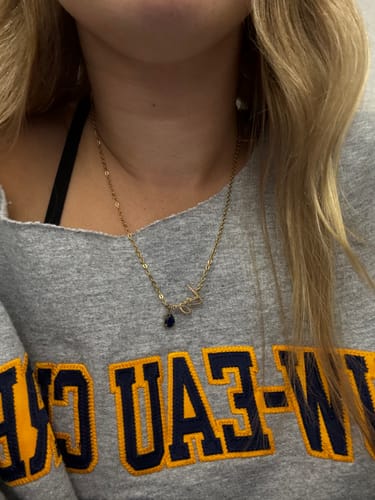 Customer's Lucce Signature Necklace, a thin gold chain with a scripted name and a small teardrop stone.