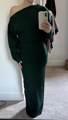 Customer's forest green off-shoulder sweater maxi dress worn by a person, showing a cozy, full-length fit.