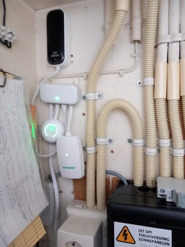 Reviewer's Zendure Smart Meter P1 installed and mounted on a wall with white cables in a home utility setting.