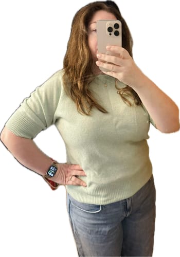 Customer's mint green short sleeve cashmere jumper being worn while taking a mirror selfie