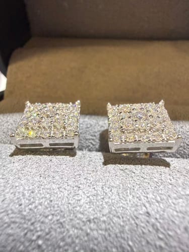 Customer's square moissanite stud earrings resting on a soft gray surface