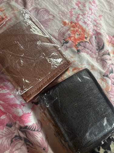 Customer's two ZIORO Spiderman wallets inside plastic packaging on a floral fabric surface.