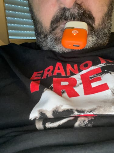 Customer's orange THC-A Vape held in their mouth