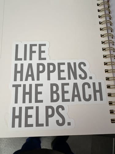 Reviewer's Life Happens The Beach Helps decal, a thick, gray sticker applied to the inside cover of a planner.