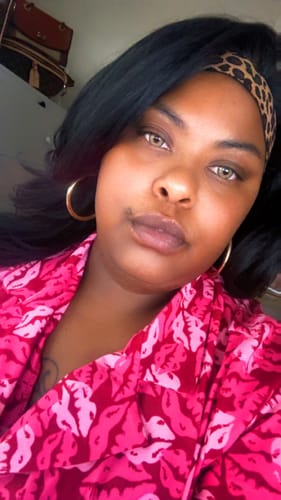 Customer's Sensationnel Bare Lace wig with wavy black hair and a leopard-print headband.