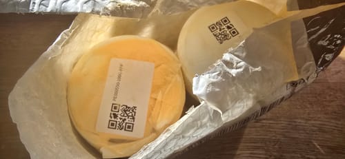 Customer's damaged shipping package containing two round, light-colored MeowSupps Taurine Supplement containers.