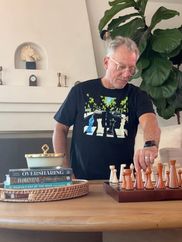 Customer's Bauhaus Chess T-shirt showing a graphic print while the reviewer plays a game at a table.