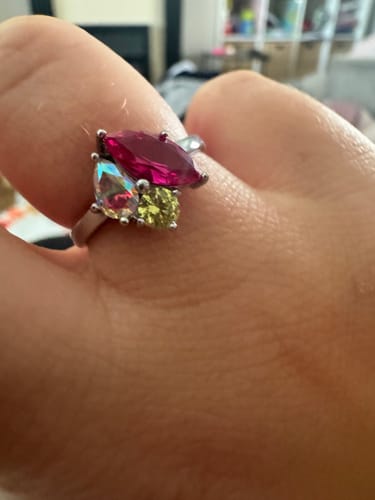 Customer's Zia Birthstone Ring featuring a marquise pink stone, pear-cut iridescent stone, and yellow round-cut stone.