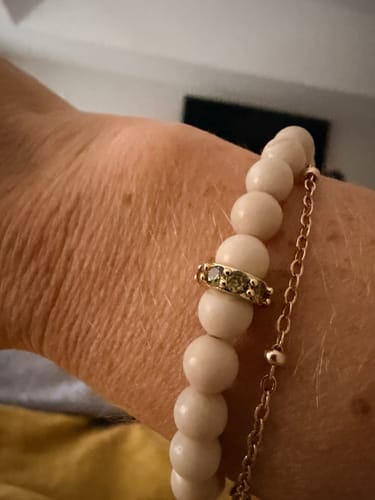 Customer's HALO BIRTHSTONE CHARM on a beaded bracelet with a thin chain.