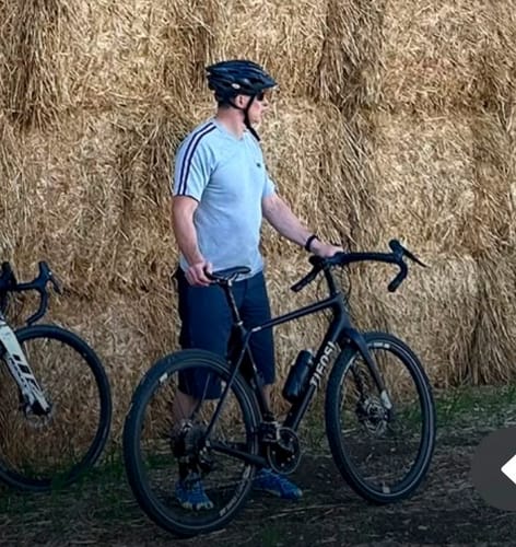 Reviewer's Active II Pro barefoot shoes on their feet while standing next to a bicycle on a country bike ride.