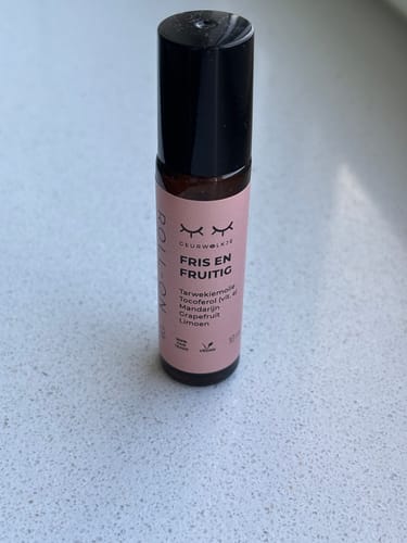 Klant's Fris en Fruitig parfumroller met etherische olie, staand op een lichtgekleurde ondergrond.