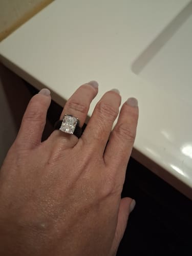 Customer's silicone ring with a large, rectangular emerald-cut stone worn on a finger