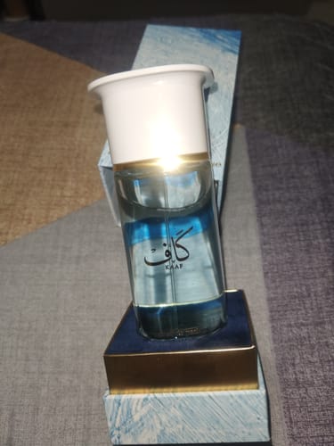 Customer's Ahmed al Maghribi KAAF perfume bottle with a white cap, standing on its blue and gold packaging.