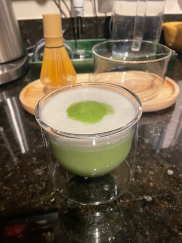 Customer's FLUR x Nami Matcha Set featuring a glass bowl of matcha and a bamboo whisk on a wooden tray.